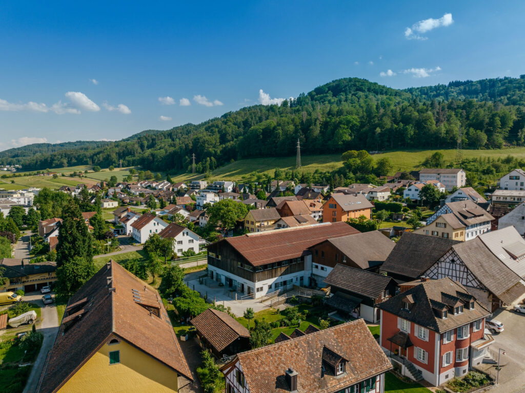 Luftaufnahme von Bauernhof und Pferdeställen, Coaching Zeitgeschenk in Neuenhof nahe Baden Aargau, Schweiz.