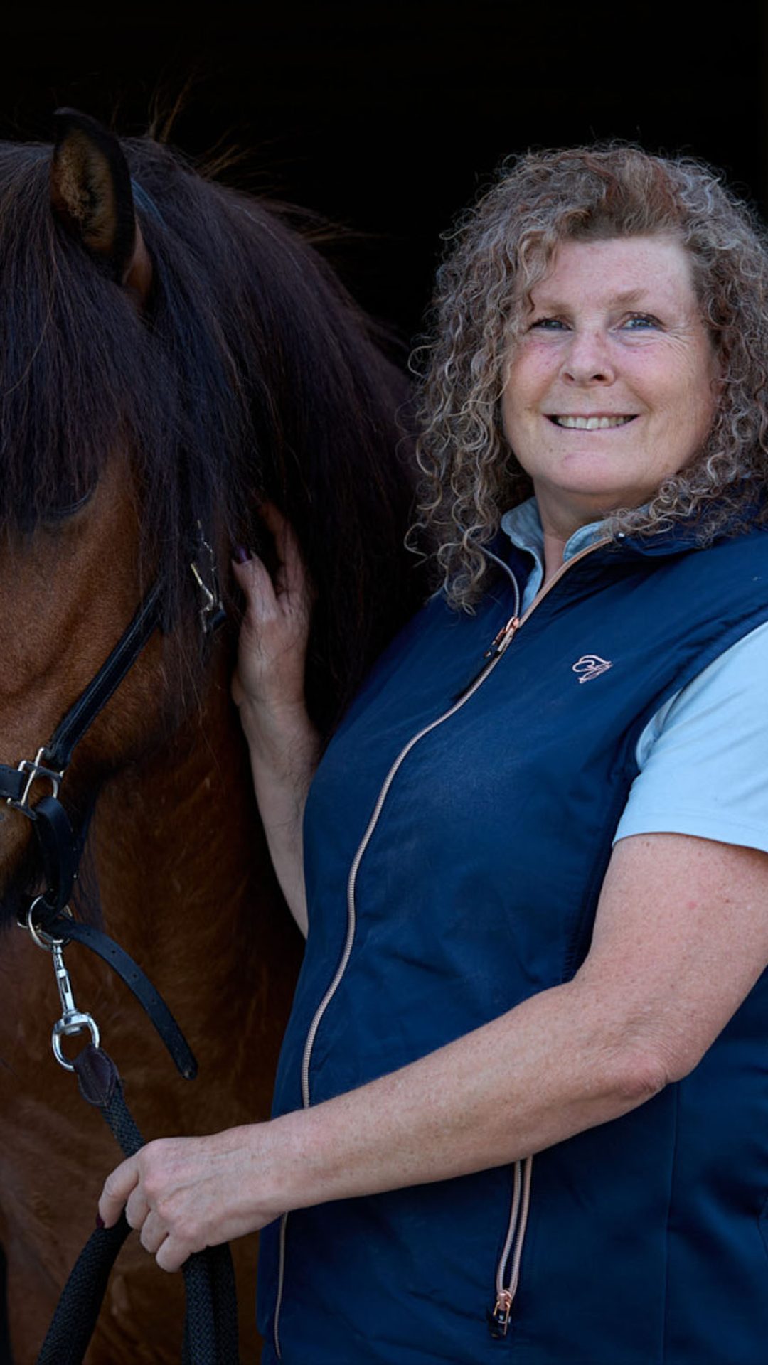 Karin neben einem Pferd stehend.